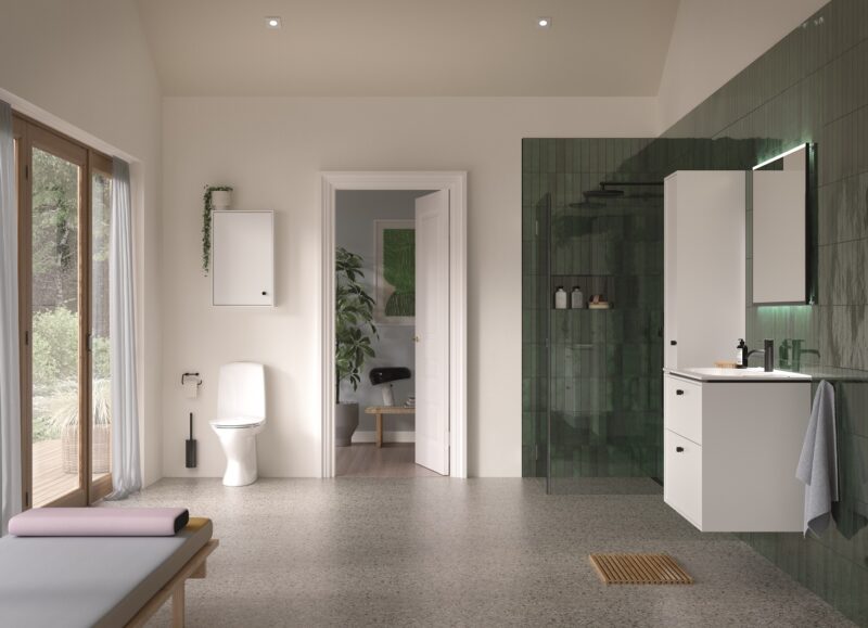 Vi Bygger Vejle: Lyst badeværelse med grønne fliser, hvidt inventar, bruser, toilet og et stort vindue.