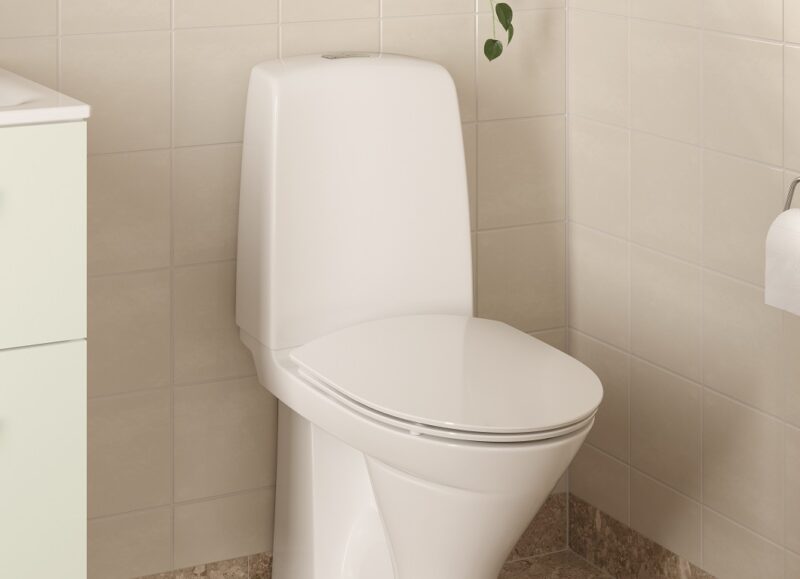 Vi Bygger Vejle: Moderne badeværelse med hvidt toilet, beige fliser og marmoreret gulv.