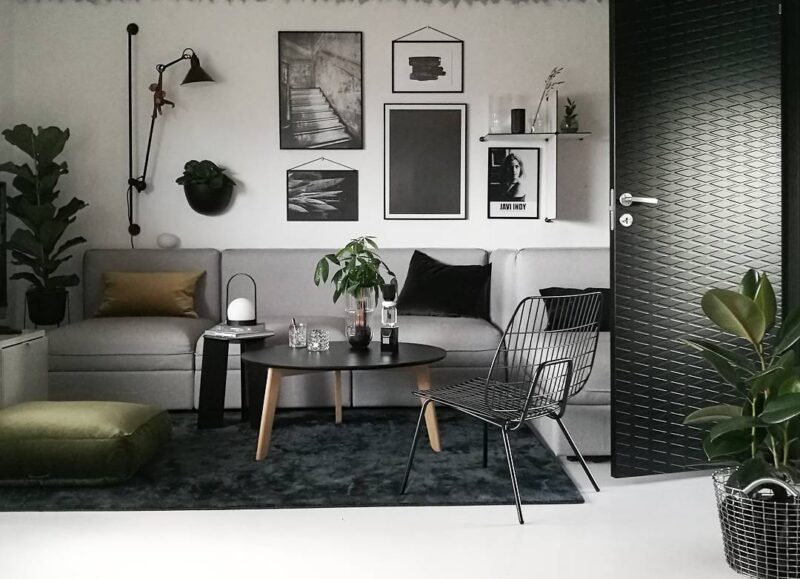 Vi Bygger Vejle: Indbydende, moderne stue med grå modulsofa, grønne planter og sort-hvid billedkunst.