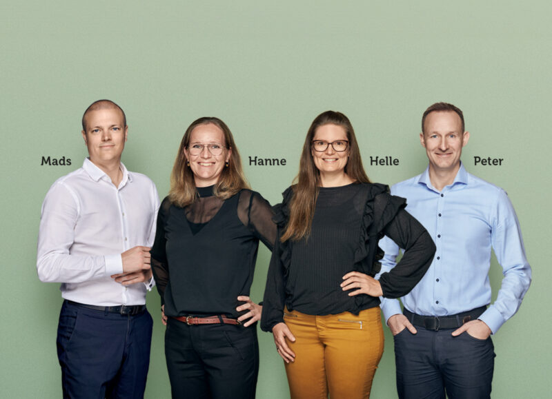 Vi Bygger Vejle: Mads, Hanne, Helle og Peter smiler foran grøn baggrund.
