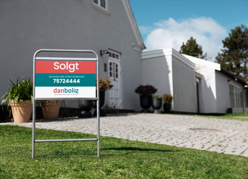 Vi Bygger Vejle: Danbolig "Solgt"-skilt foran lyst hus med græsplæne og indkørsel.