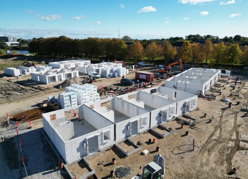 Vi Bygger Vejle: Dronefoto af byggeplads med rækkehuse under opførelse, H+H blokke og efterårstræer.