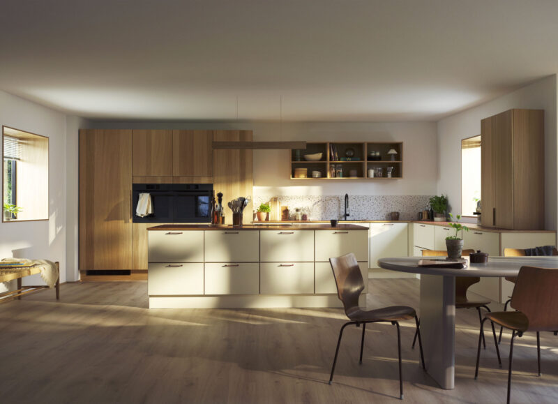 Vi Bygger Vejle: Moderne køkken med træskabe, lys ø og spisebord. Sollys falder ind ad vinduet.