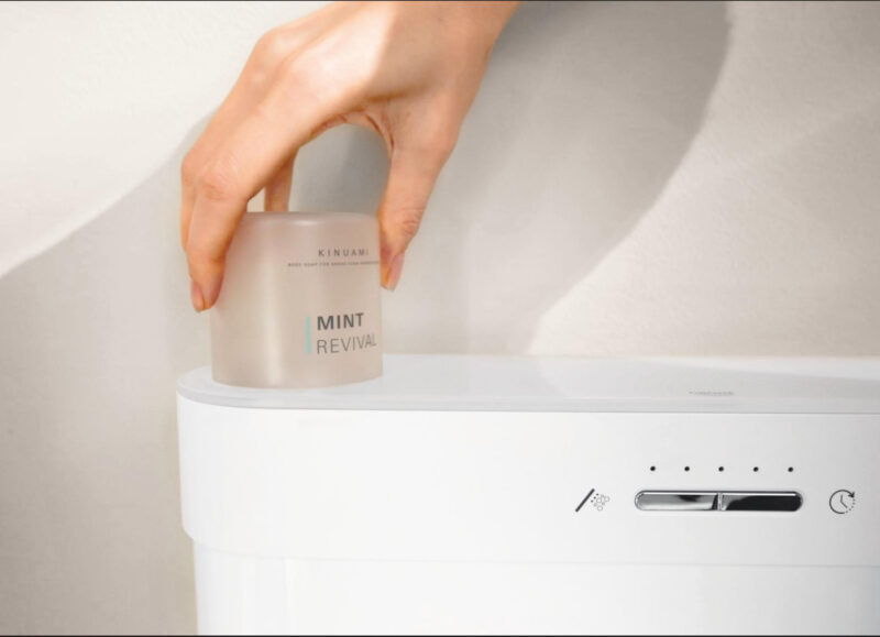 Vi Bygger Vejle: Hånd placerer Kinuami Mint Revival sæbe på et hvidt GROHE toilet med kontrolpanel.