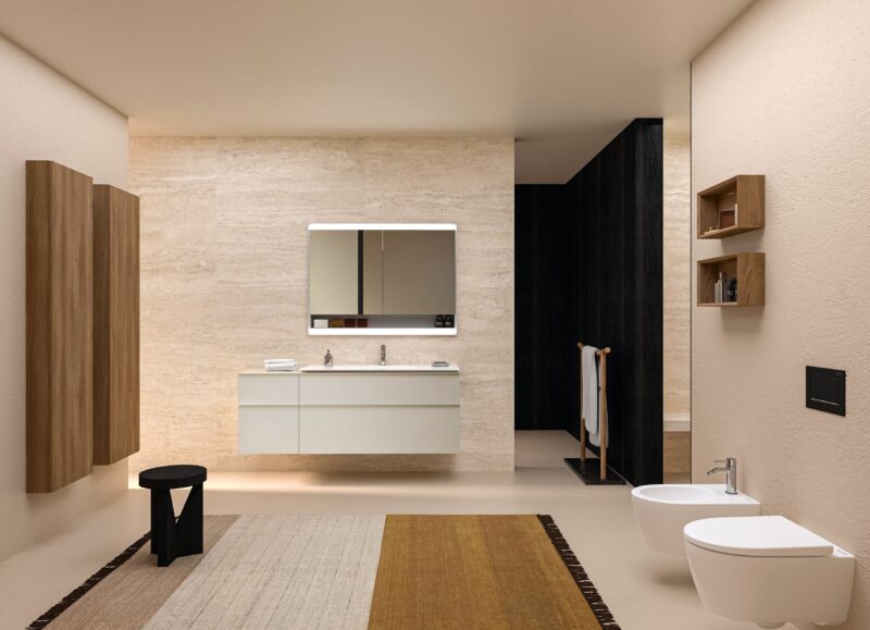 Vi Bygger Vejle: Moderne badeværelse med dobbeltvask, trædetaljer, lyst gulv og vægge samt toilet og bidet.